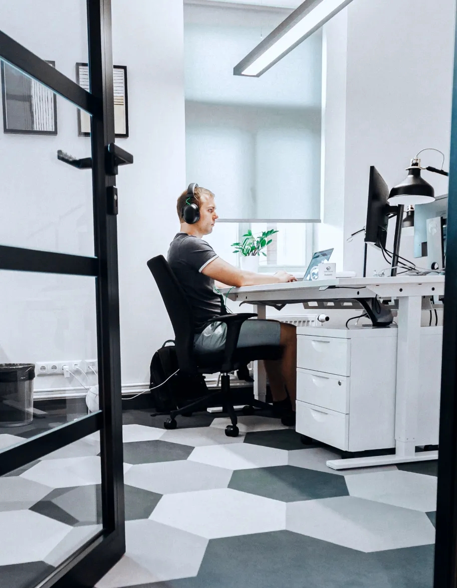 Et kontorarbeidsområde med en QA-ingeniør som sitter ved et skrivebord og arbeider.