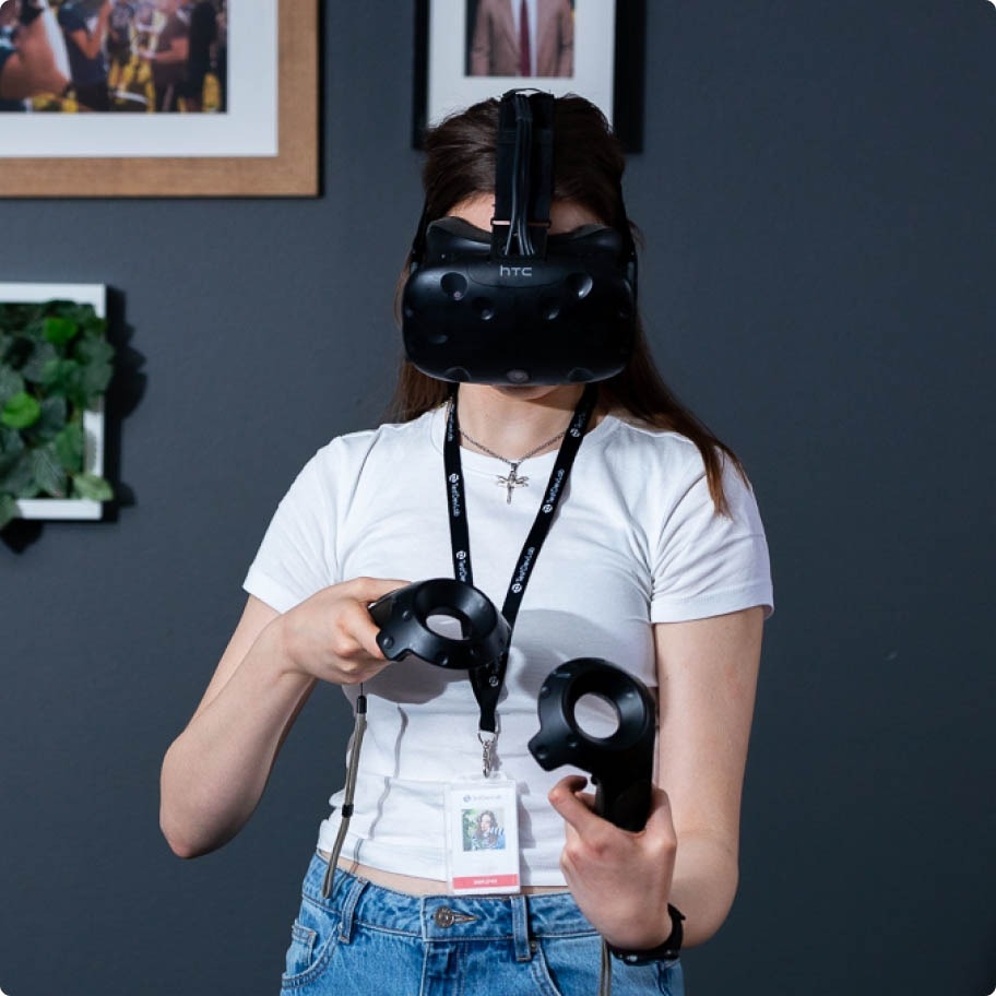 QA inženieris ar VR brillēm un ar VR kontrolleriem abās rokās, testējot patērētāju klases VR risinājumu.