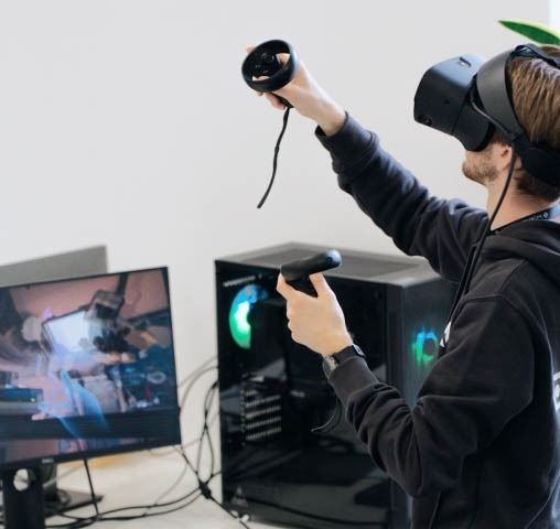 Qualitätsprüfungsexperte trägt ein VR-Headset und führt Softwaretestaktivitäten durch.