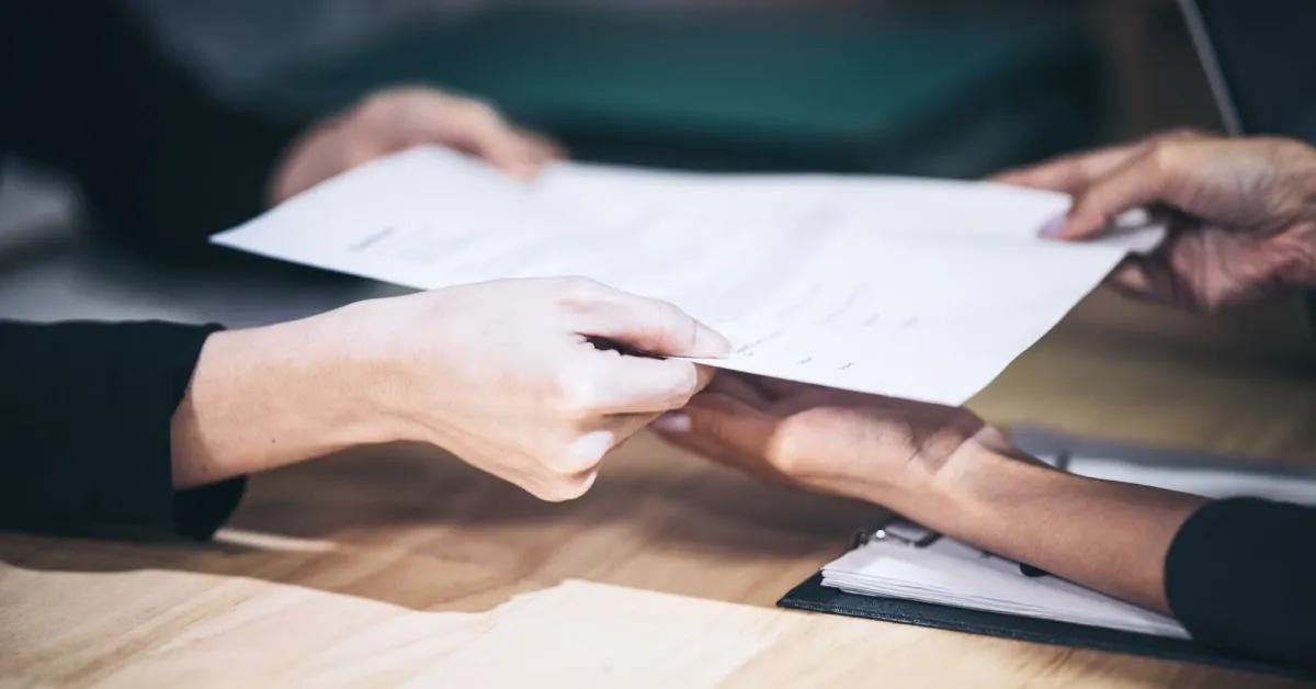 Two people handling printed documents.