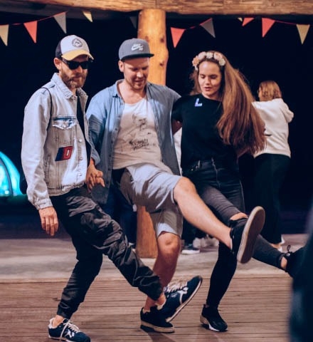 Three people dancing at the company event.