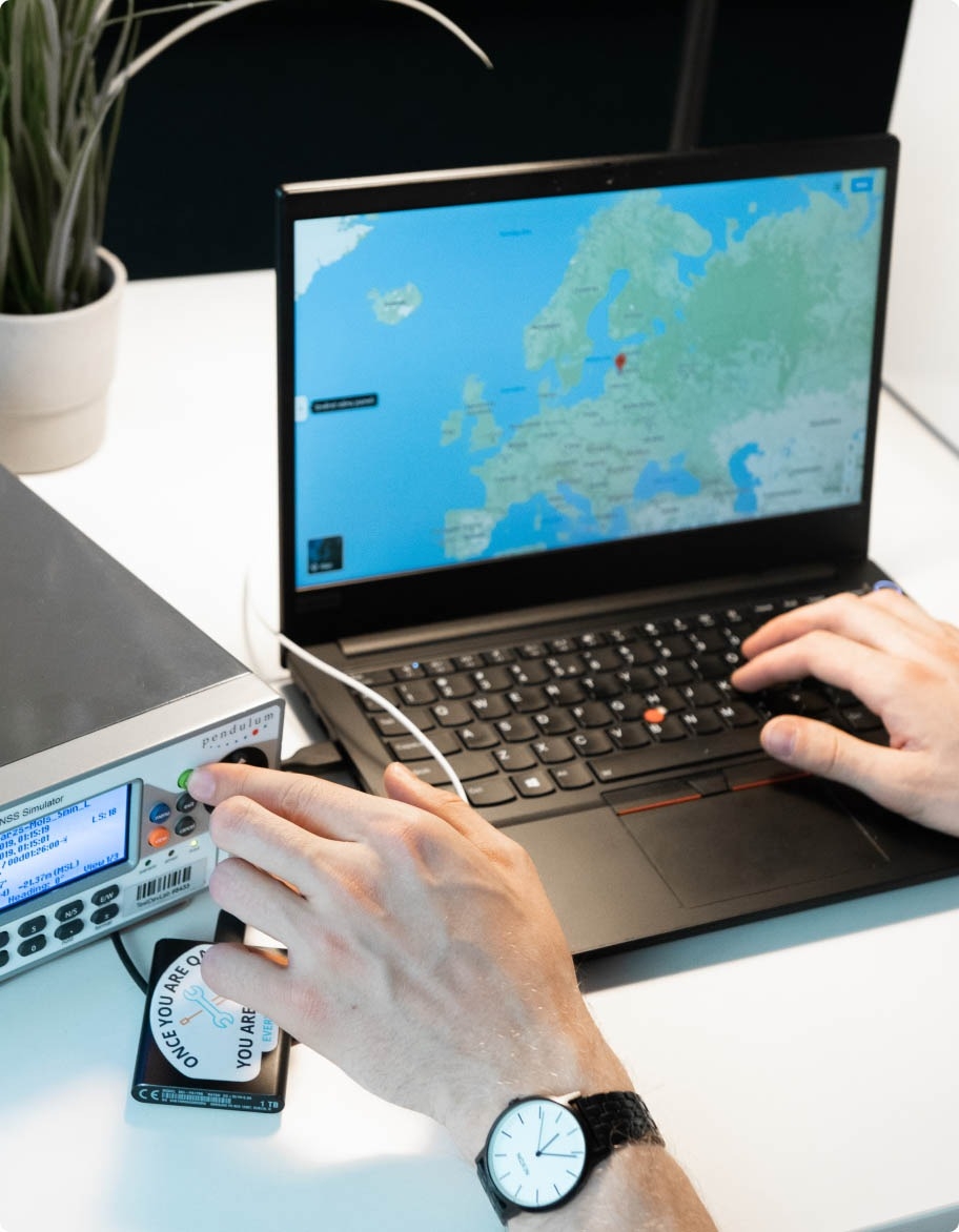 Mobile application testing engineer setting up location testing setup with the help of a laptop and other hardware equipment.