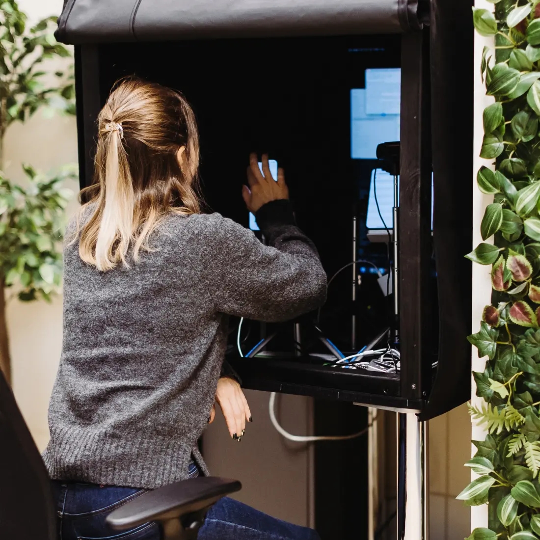 QA engineer performing audio and video quality testing using a specialized setup.