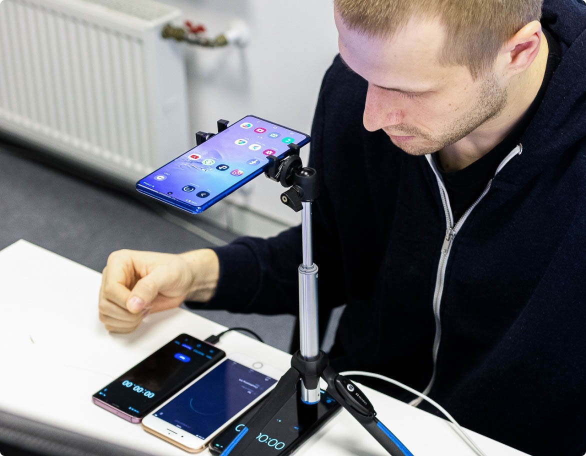 QA engineer looking at multiple devices on a desk from various manufacturers with different specifications.