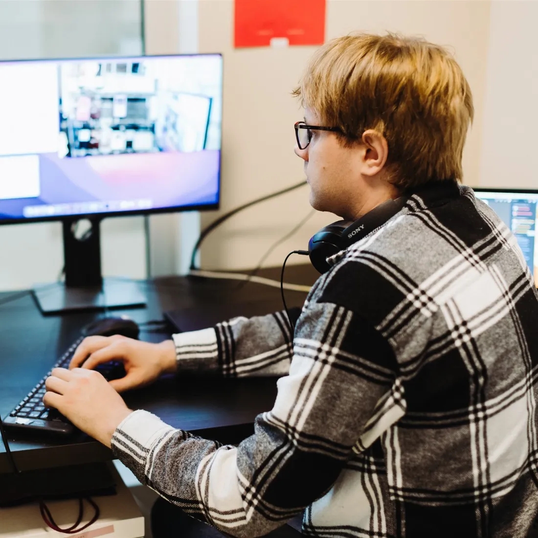 Side view of a QA engineer typing at a computer.