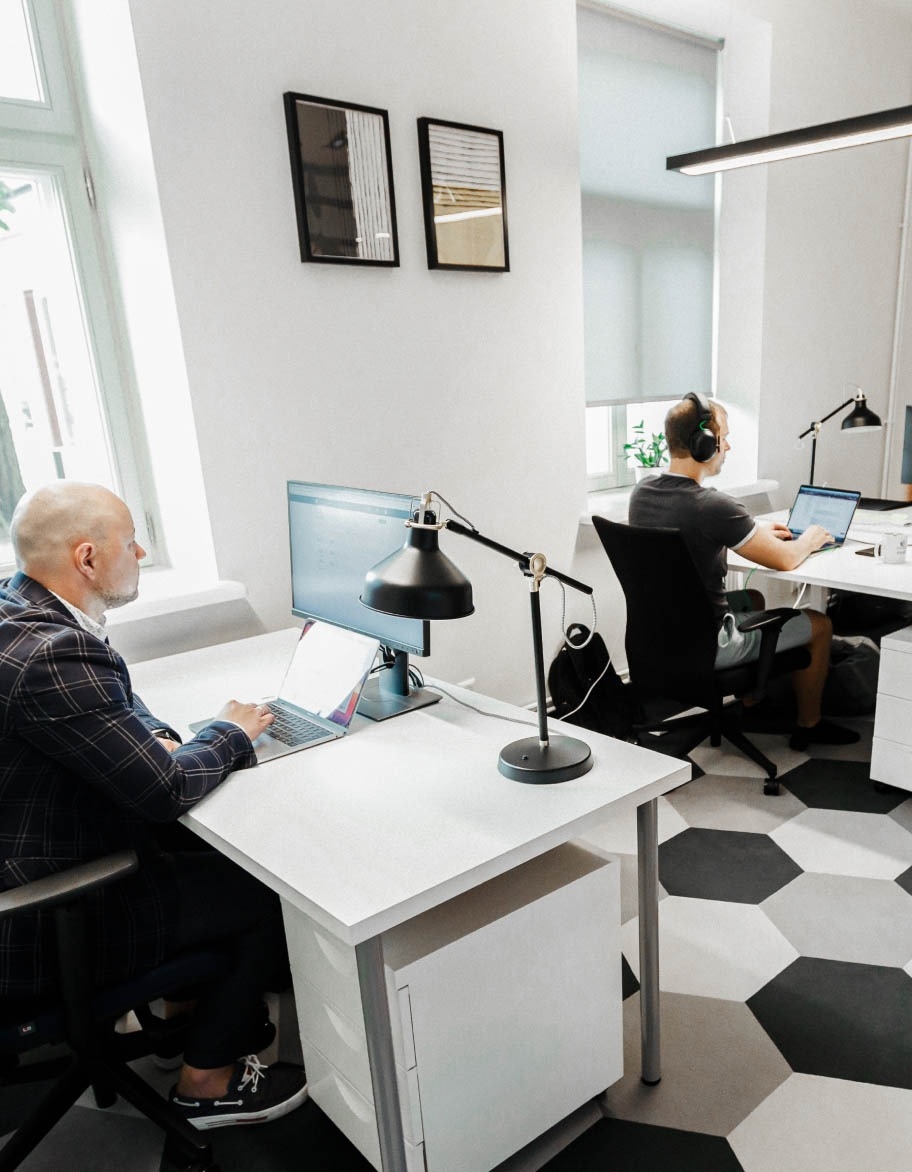 Two quality assurance engineers sitting at their desks and working on projects.