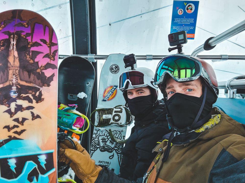 Miks Ratnieks, Video Editor & Photographer at TestDevLab, with a friend holding snowboards