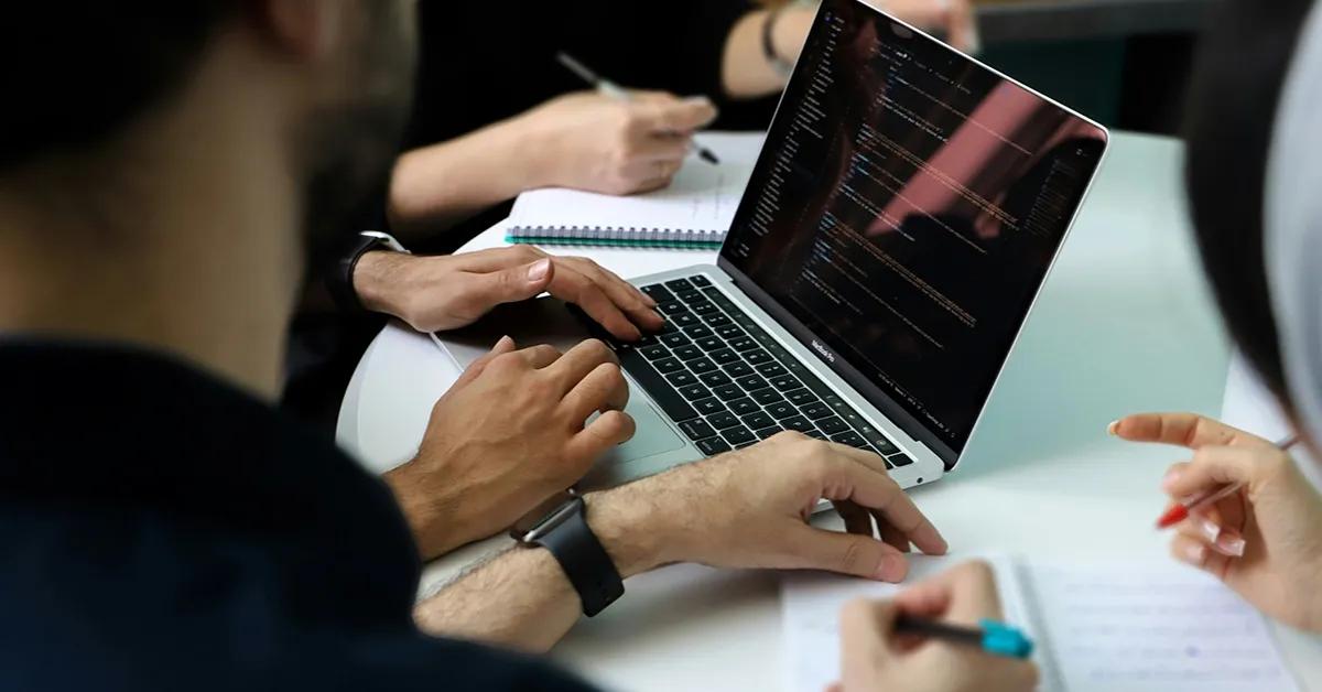 Software testers looking at laptop screen