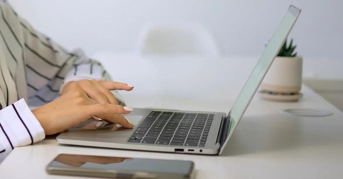 Side view of a woman typing on a laptop