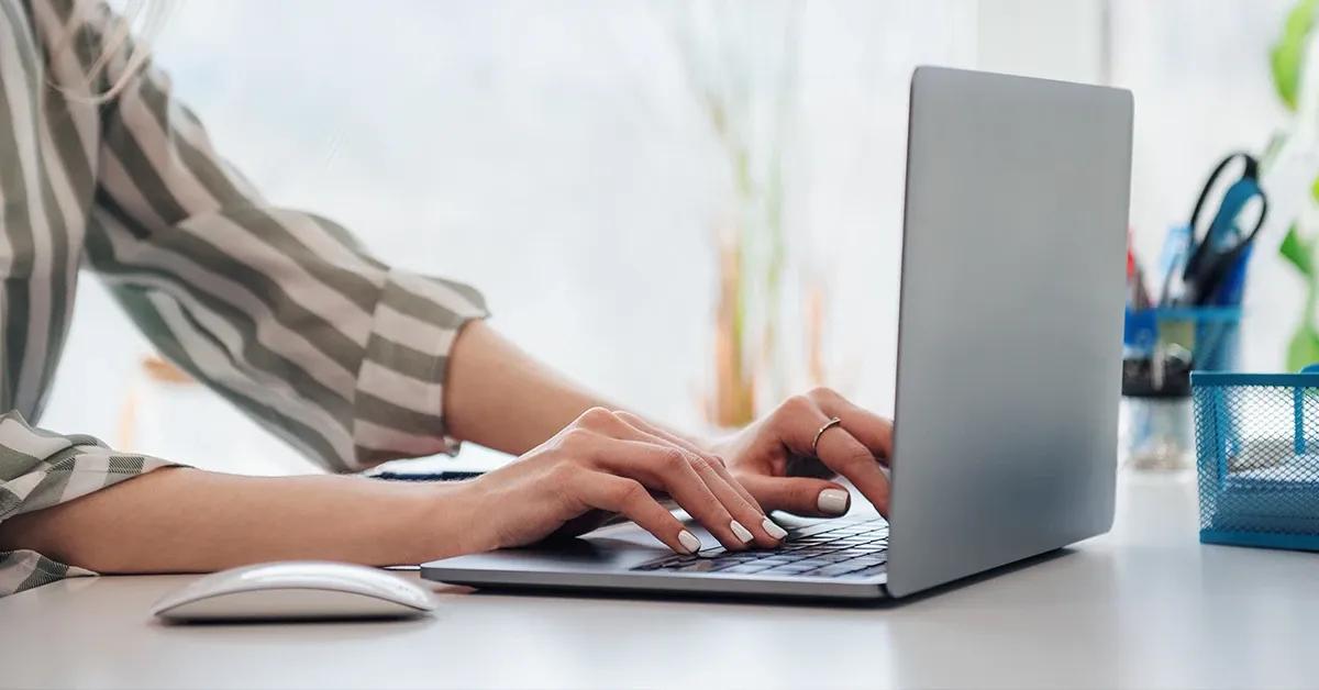 Side view of a woman working on a laptop