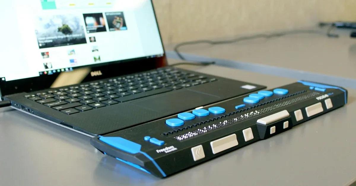 A laptop with a Braille keyboard and screen reader attached to it