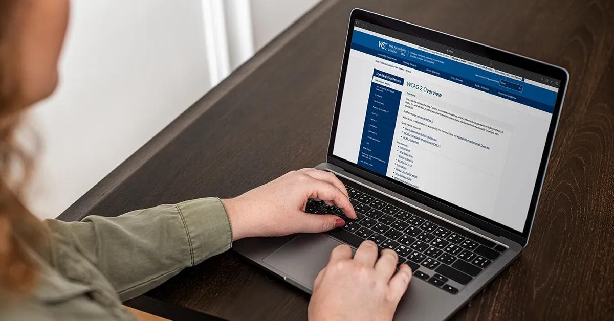 Woman reading the Web Content Accessibility Guidelines on her laptop