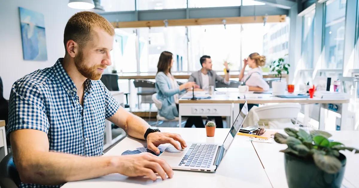 QA engineer working on a laptop in an office space